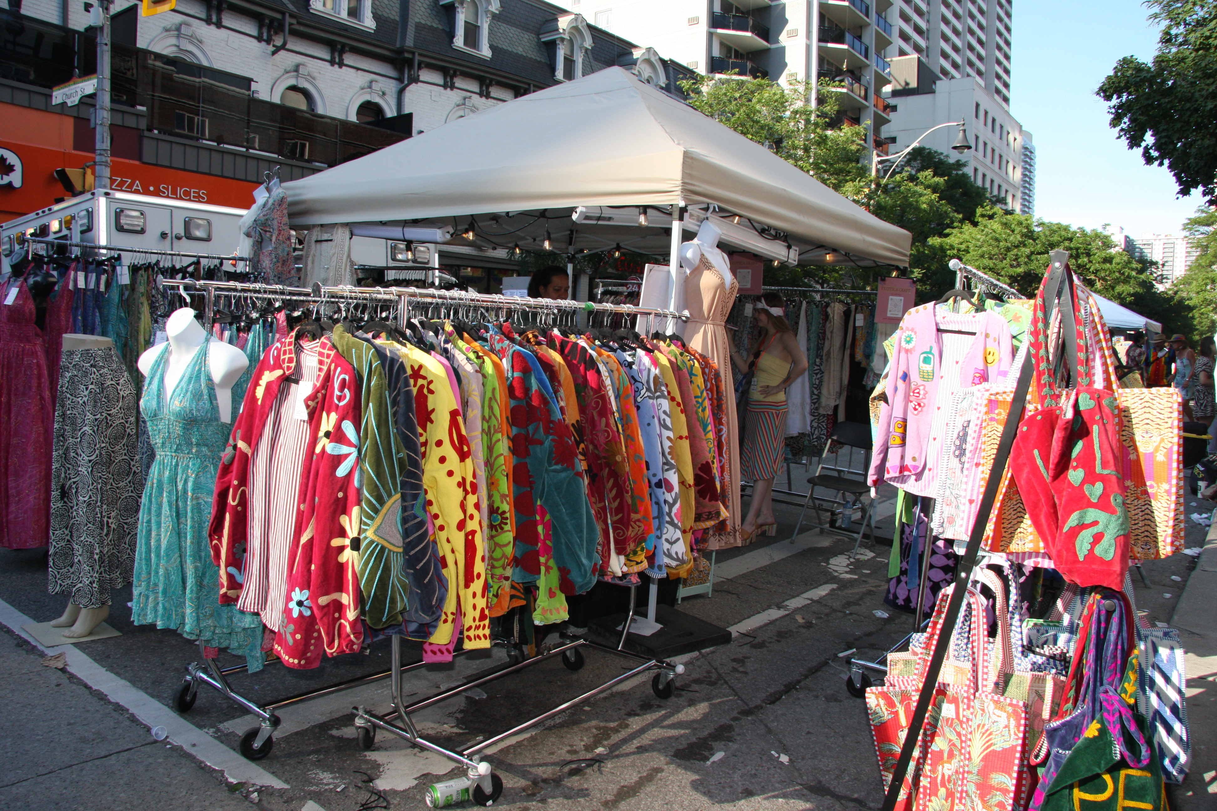 Colorful embroidered vintage jackets and patterned dresses on display at Exotica Craft's Church Street booth.